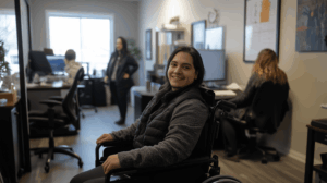 Person in wheelchair in office with coworkers near them