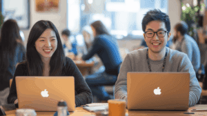 2 coworkers at their laptops in office
