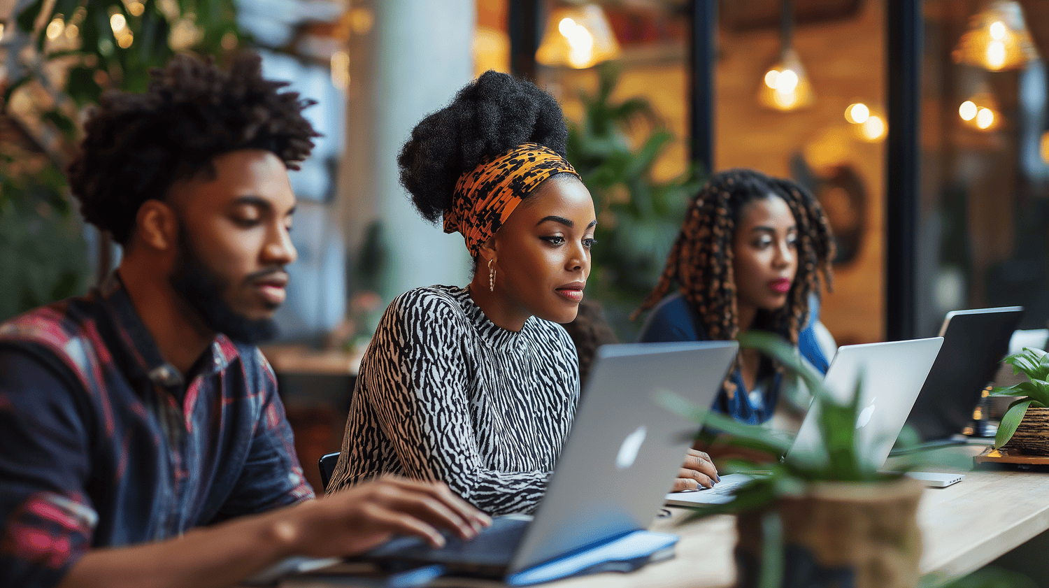 Coworkers working in the office next to each other on laptops