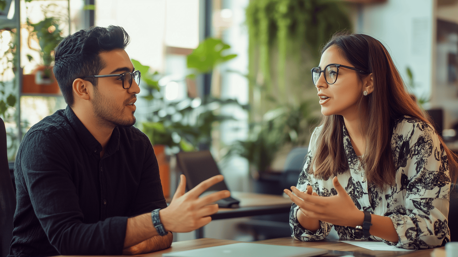 Two Hispanic colleagues talking at their workplace